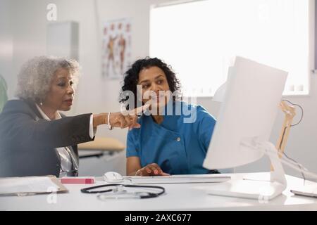 Female doctor and patient using computer in doctors office Stock Photo