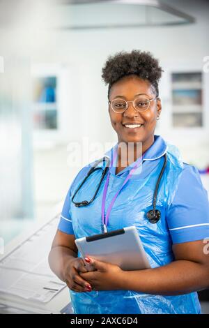 Portrait confident female nurse with digital tablet Stock Photo