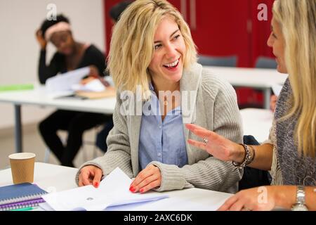 Female community college students talking, studying in classroom Stock Photo