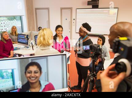 Community college students filming in media classroom Stock Photo