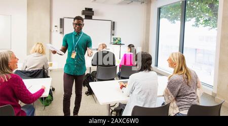 Male community college instructor leading lesson in classroom Stock Photo