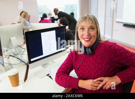 Portrait confident mature female community college student using computer in computer lab Stock Photo