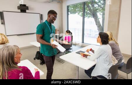 Community college instructor talking with students in classroom Stock Photo