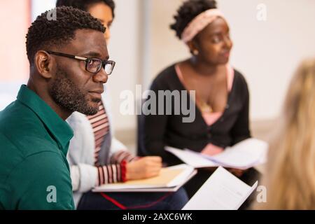 Attentive, focused businessman with paperwork listening in meeting Stock Photo
