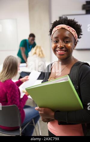 Portrait confident female college student with binder in classroom Stock Photo