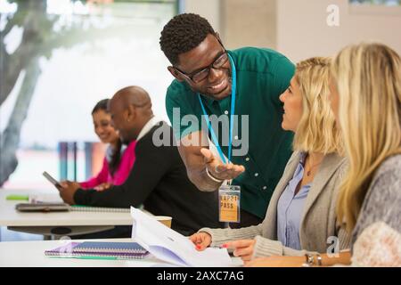 Community college instructor helping students in classroom Stock Photo