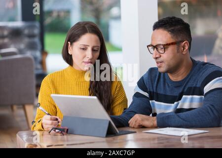 Couple paying bills at digital tablet Stock Photo