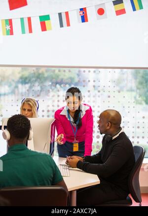 Community college instructor helping students using computers in computer lab Stock Photo