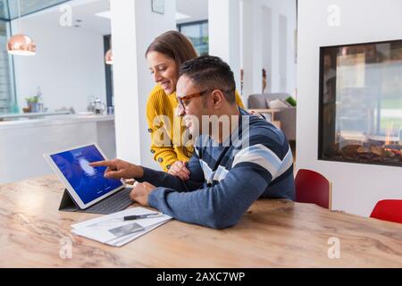 Couple paying bills at digital tablet Stock Photo
