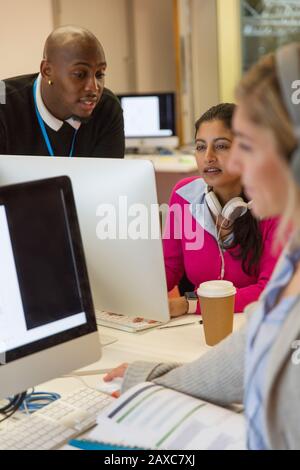 Students working at computers in classroom Stock Photo