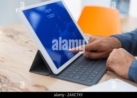 Close up man using digital tablet, logging on Stock Photo