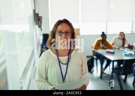Portrait confident female high school teacher at projection screen in classroom Stock Photo