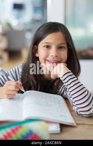 Portrait confident, smiling girl doing homework Stock Photo