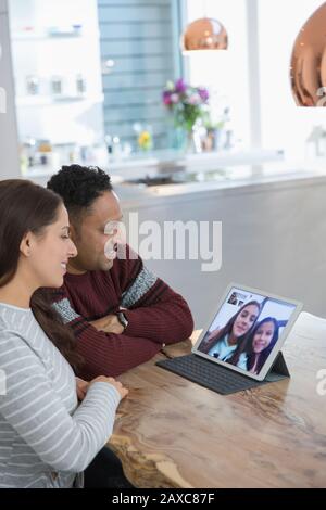 Parents video conferencing with daughters at digital tablet Stock Photo