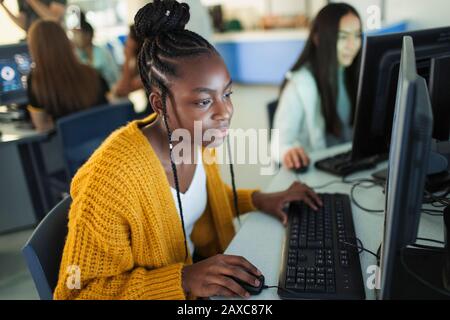 Focused junior high girl student using computer in computer lab Stock Photo