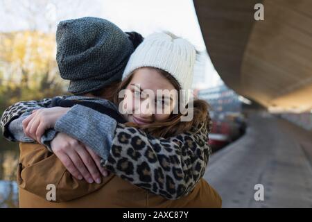 Portrait happy young woman hugging boyfriend Stock Photo