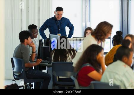 Junior high students and teacher using computers in computer lab Stock Photo