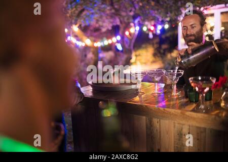 Bartender pouring cocktails at garden party Stock Photo