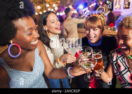 Happy women friends toasting cocktails at party Stock Photo