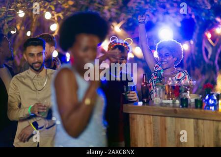 Friends dancing and drinking at garden party Stock Photo