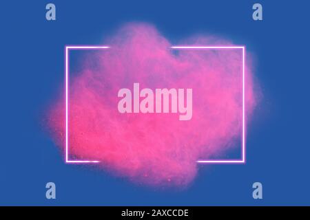 Pink neon powder explosion with gliwing frame on blue background. Colored cloud. Colorful dust explode. Stock Photo