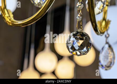 Pendant on a chandelier in the shape of a crystal ball with a beautiful facet. Stock Photo