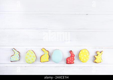 Yellow tulips and Easter gingerbread cookies on white wooden table. Spring or  Easter holiday concept, Copy space, flat lay, Template mockup greeting Stock Photo