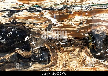 Glossy marble with brown, black and white patterns. A sample of natural marble with a pronounced texture. Stock Photo