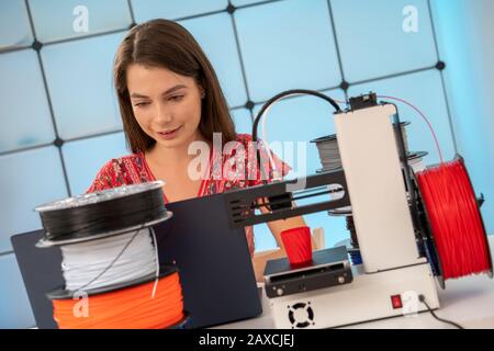 Young female designer works with a home 3D printer Stock Photo