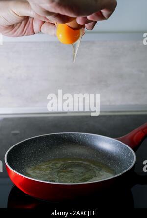 Preparing scrambled eggs - sticking the eggs in the pan Stock Photo