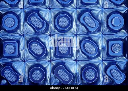 The texture of the plastic packaging of chocolates top view. Empty candy box background in blue. Stock Photo