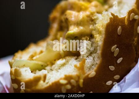 Close up detail of a bitten cheeseburger. Food, junk food and fast food concept Stock Photo