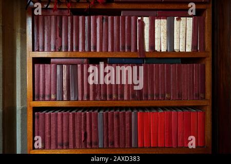 Old and worn hymn books on a bookcase in a church Stock Photo