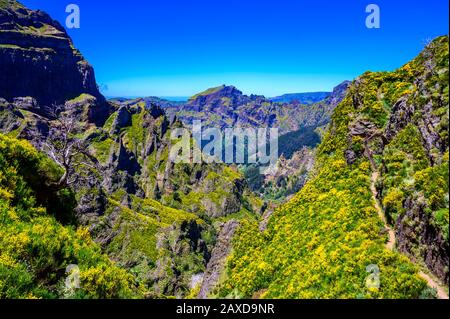 Beautiful hiking trail from Pico do Arieiro to Pico Ruivo, Madeira island. Footpath PR1 - Vereda do Areeiro. On sunny summer day above the clouds. Por Stock Photo