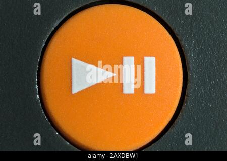 Macro close up photograph of orange play or pause button on vintage portable tape player. Stock Photo
