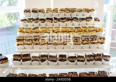 Assortment of pieces of cake on messy table, copy space. Several slices of delicious desserts, restaurant menu concept, top view Stock Photo