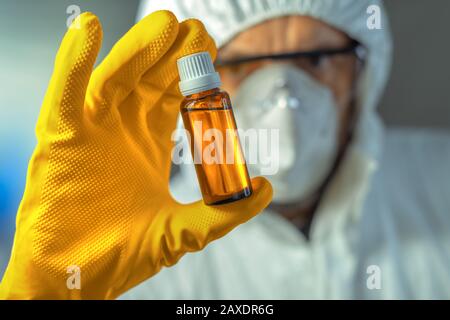 Medical worker holding glass bottle of syrup, close up with selective focus Stock Photo