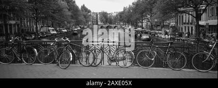 Bicycle Leaning Against A Metal Railing On A Bridge, Amsterdam, Netherlands Stock Photo