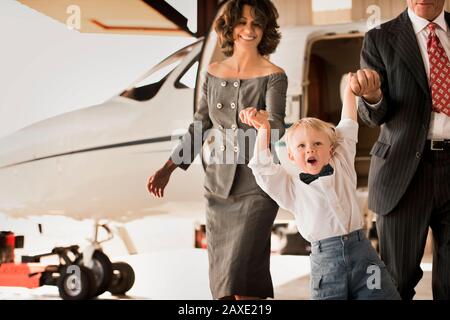 A couple swinging their son in the air Stock Photo