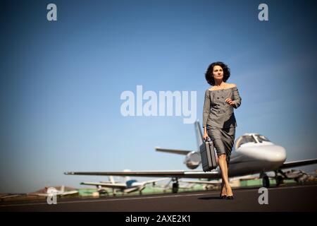 A businesswoman leaving a plane at the airport Stock Photo