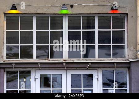 Three electric lamps above the large window depict the Lithuanian flag - tricolor: yellow, green and red. Decoration of the building on the occasion o Stock Photo