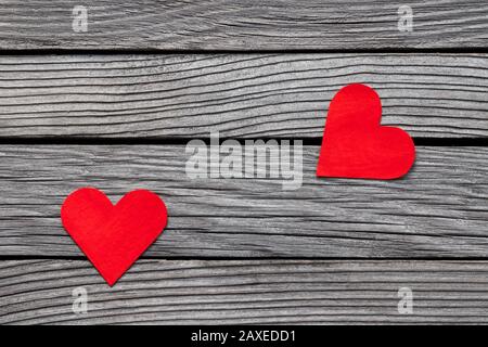 Couple of red paper hearts on gray wood, simple love story, break up Stock Photo