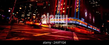 Low angle view of buildings lit up at night, Radio City Music Hall, Rockefeller Center, Manhattan, New York City, New York State, USA Stock Photo