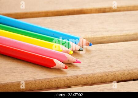 Closeup shot of five color pencils on a wooden pallet Stock Photo