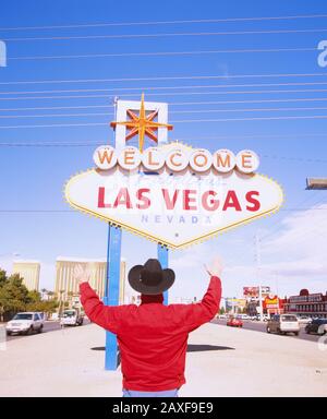 Rear view of a man standing in front of a welcome sign board, Las Vegas, Nevada, USA Stock Photo