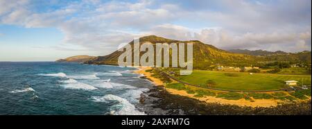 Panorama of Koko Head crater taken from a drone in Hawaii with both a rocky and a sandy beach with the incoming surf from the Pacific Ocean in morning Stock Photo