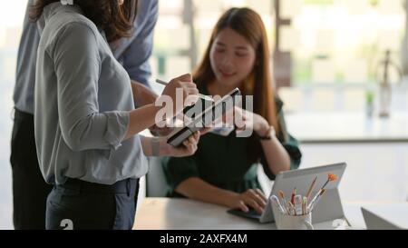 Cropped shot of UI designer team discussing the project together while using tablet in modern office room Stock Photo