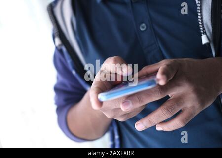 close up of young man use smart phone texting message Stock Photo