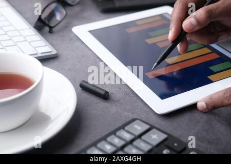 man hand analyzing financial chart on digital tablet  Stock Photo