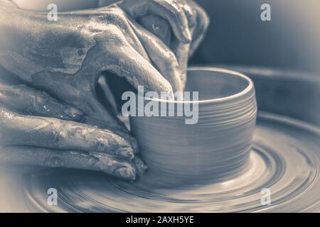 Old vintage photo. The potter molds clay jug pot closeup. Monochrome, Black and white Stock Photo
